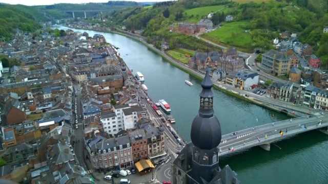 The City of Dinant. The bridge seen below is known as Charles-de-Gaulle Bridge. The bridge attracts with huge models of colourful saxophones under national flags of European countries